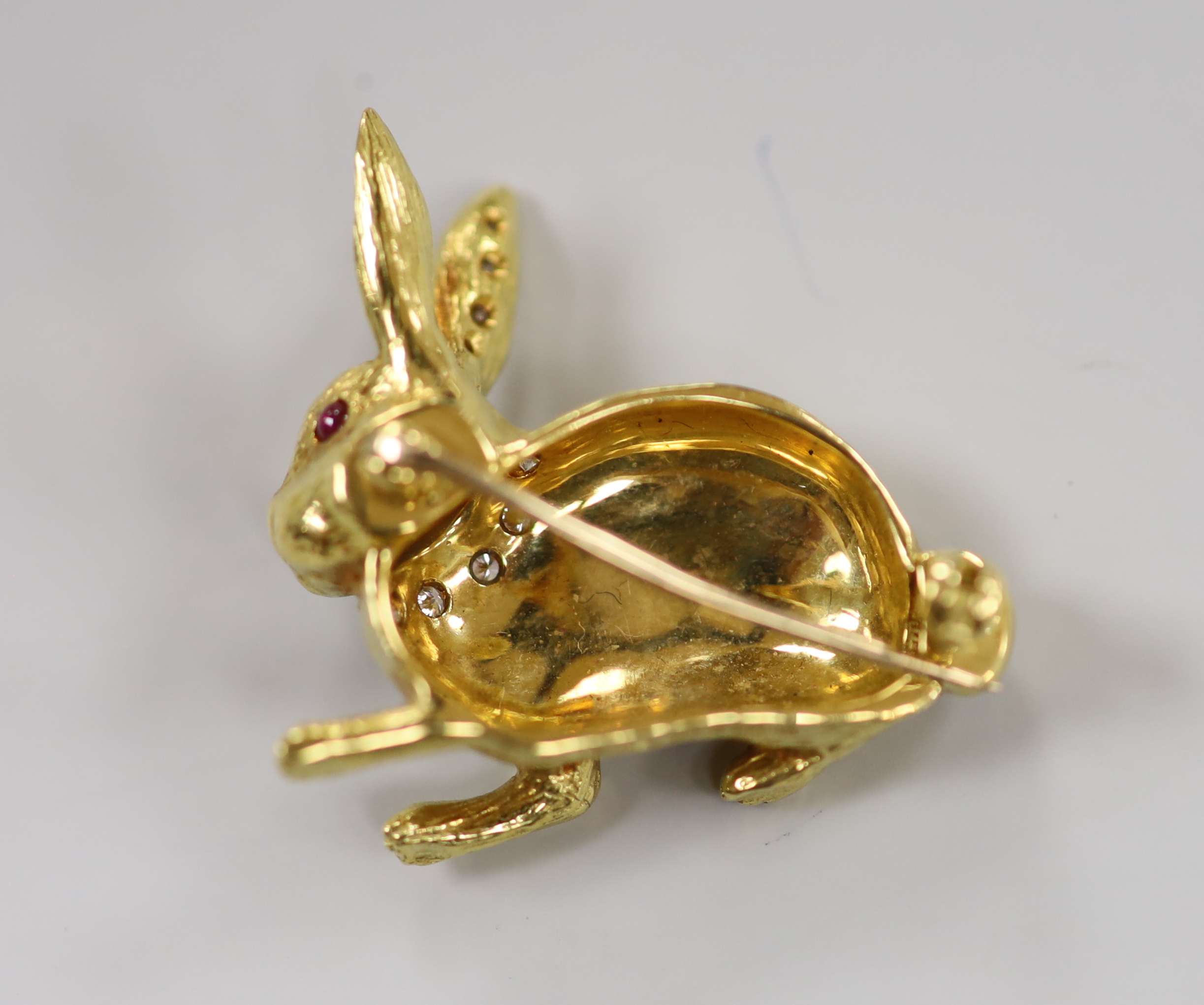 A modern 18ct yellow gold, diamond and ruby set novelty brooch, in the form of a seated hare, marked and initialled EW & Co, 27mm, gross weight 14.7 grams.